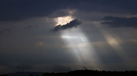 Sonnenstrahlen dringen am Abend durch Wolkenlücken über dem Fernmeldeturm Weichberg. / Foto: Karl-Josef Hildenbrand/dpa