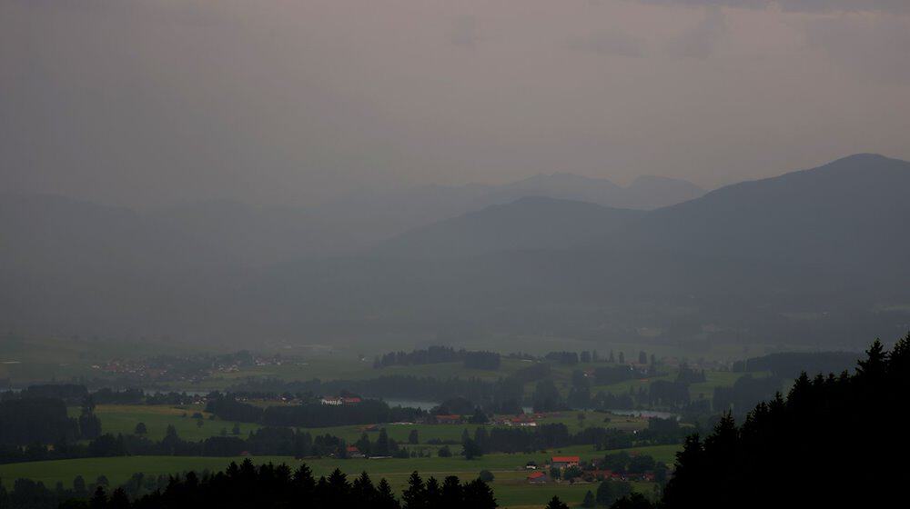 Regen fällt aus dichten Regenwolken über den Bergen und auf das Alpenvorland. / Foto: Karl-Josef Hildenbrand/dpa