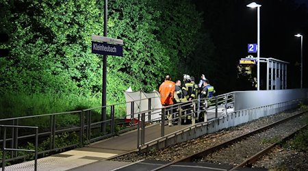 Rettungskräfte stehen an einem Bahnsteig in Kleinheubach. / Foto: Ralf Hettler/dpa