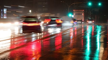 Die Lichter von Ampeln und Fahrzeugen spiegeln sich im Regen auf einer Straße. / Foto: Marcus Brandt/dpa/Symbolbild