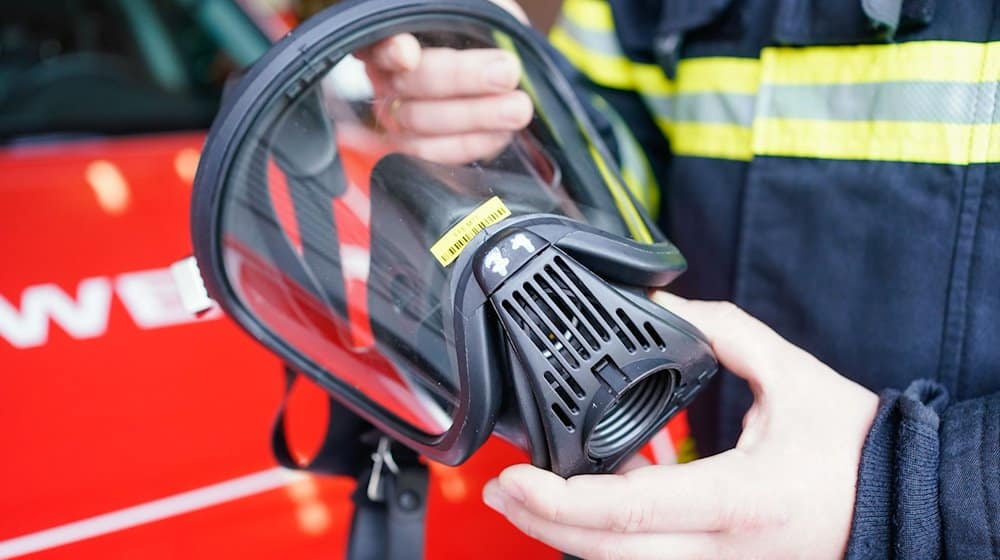 Ein Feuerwehrmann hält eine Atemmaske in den Händen. / Foto: Uwe Anspach/dpa/Symbolbild