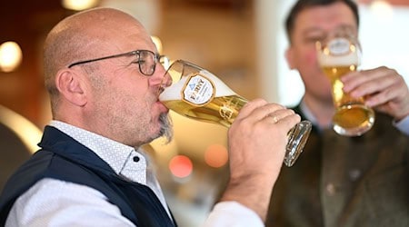 Elmar Bentele (r), Geschäftsführer der Edelweißbrauerei Farny, und Braumeister Wolfgang Sigg, nehme im Sudhaus eine Schluck Kristall-Weizen, nachdem sie angestoßen haben. / Foto: Felix Kästle/dpa