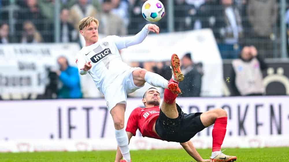 Thore Jacobsen (l) vom SV Elversberg und Ivan Prtajin vom SV Wehen Wiesbaden im Zweikampf. / Foto: Silas Schueller/DeFodi Images/dpa/Archivbild