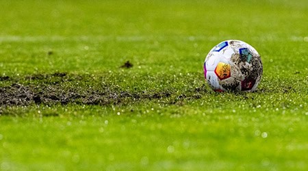 Ein Fußball liegt am Elfmeterpunkt im matschigen Rasen. / Foto: David Inderlied/dpa/Symbolbild