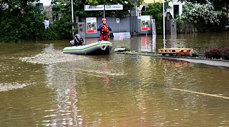 Ein Helfer kommt mit dem Schlauchboot zu einer überschwemmten Tankstelle in Allershausen. / Foto: Felix Hörhager//dpa