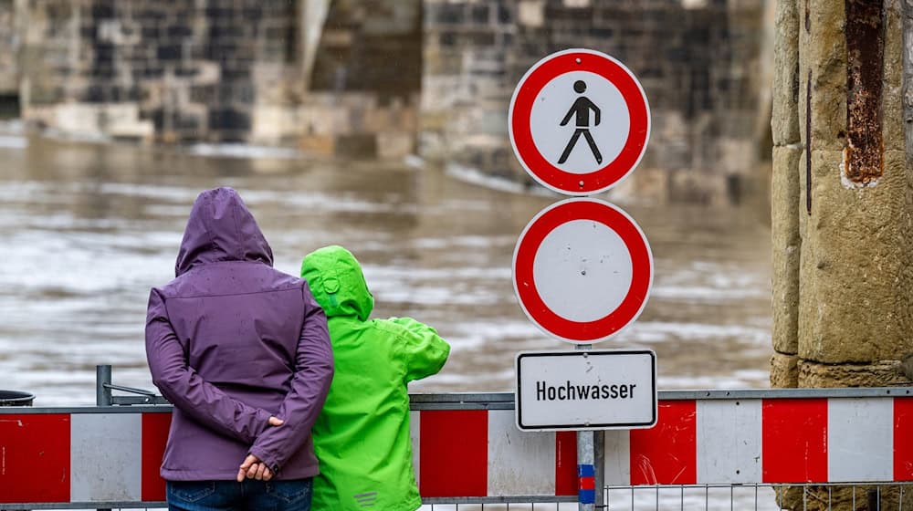 Ein Schild warnt an der Steinernen Brücke vor dem Hochwasser der Donau. / Foto: Armin Weigel/dpa