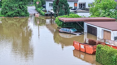 Ein Auto steht auf einer überfluteten Straße. Es ist zu erwarten, dass die Pegelstände weiter steigen werden. / Foto: Jason Tschepljakow/dpa