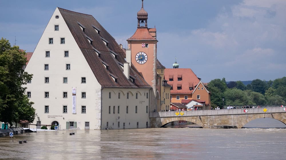 Menschen stehen in der Altstadt auf der Steinernen Brücke und schauen sich das Hochwasser an. / Foto: Sven Hoppe/dpa
