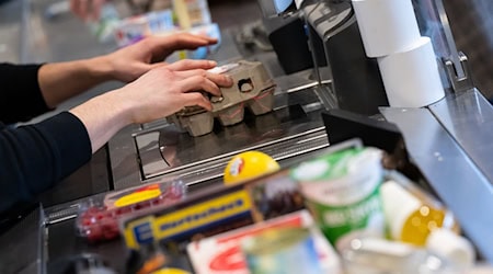 Ein Kassierer scannt in einem Supermarkt an der Kasse die Produkte. / Foto: Sven Hoppe/dpa