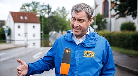 Markus Söder (CSU), Parteivorsitzender und Ministerpräsident von Bayern, gibt am Rande eines Besuchs anlässlich Hochwasserlage an einer überfluteten Straße nahe der Donaubrücke ein Interview. / Foto: Matthias Balk/dpa