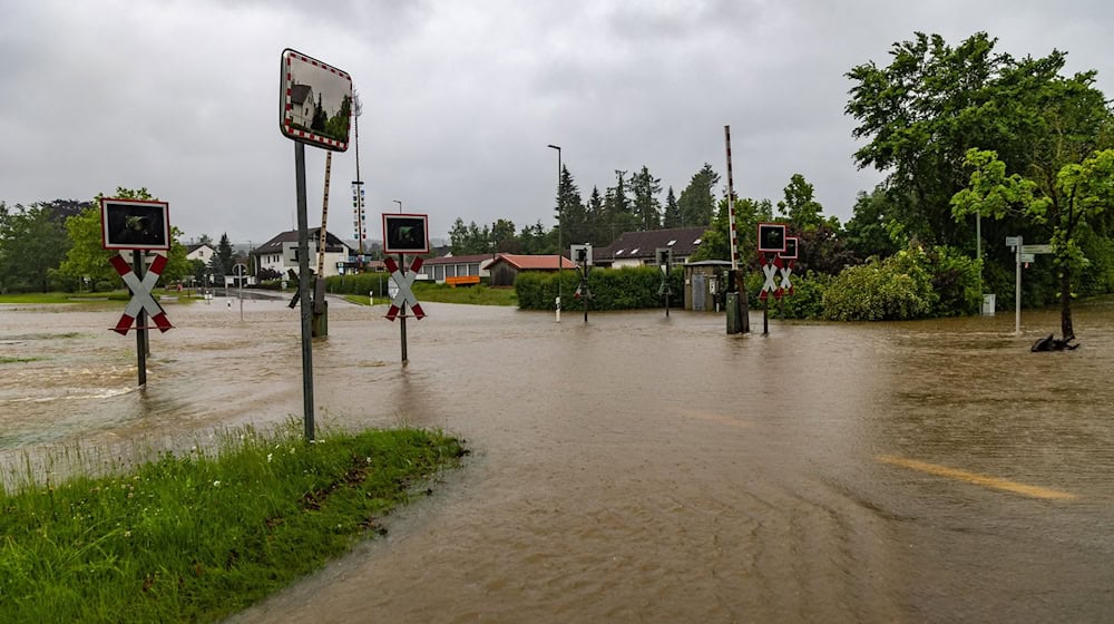 In Fischach im schwäbischen Landkreis Augsburg stehen eine Straße udn ein Bahnübergang unter Wasser. / Foto: Hartl/vifogra/dpa