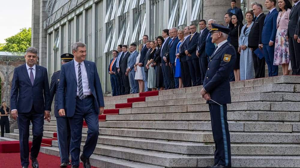 Markus Söder (r, CSU) begrüßt den rumänischen Premierminister Marcel Ciolacu vor der Bayerischen Staatskanzlei. / Foto: Peter Kneffel/dpa