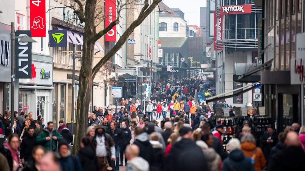 Passanten gehen während des verkaufsoffenen Sonntags durch die Innenstadt. / Foto: Daniel Bockwoldt/dpa