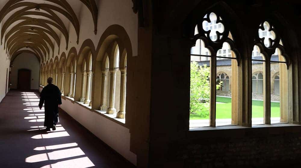 Ein Mönch läuft durch den Kreuzgang des Franziskanerklosters. Das Kloster in Würzburg ist das älteste erhaltene Franziskanerkloster Deutschlands. / Foto: Karl-Josef Hildenbrand/dpa