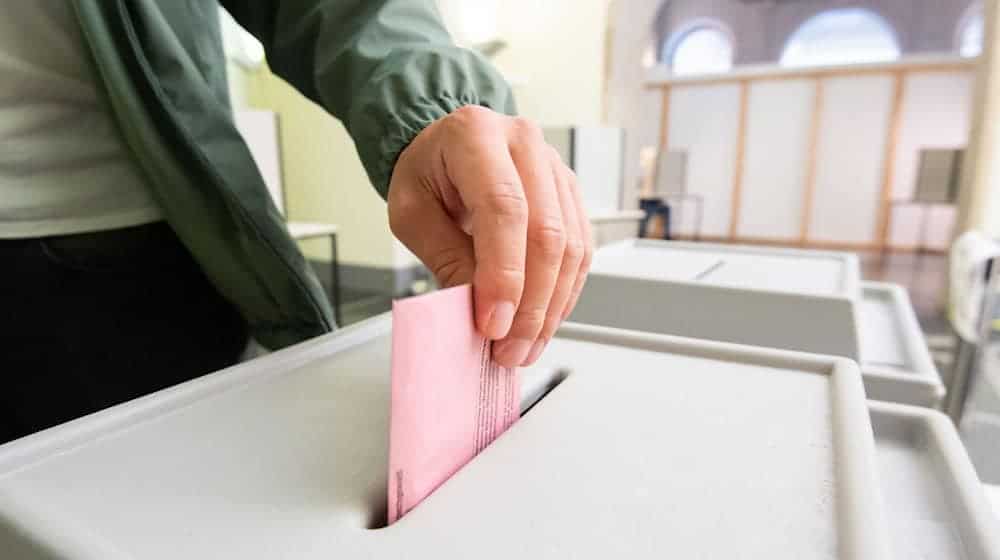 Ein Mann wirft seinen Stimmzettel in eine Urne. / Foto: Julian Stratenschulte/dpa/Symbolbild