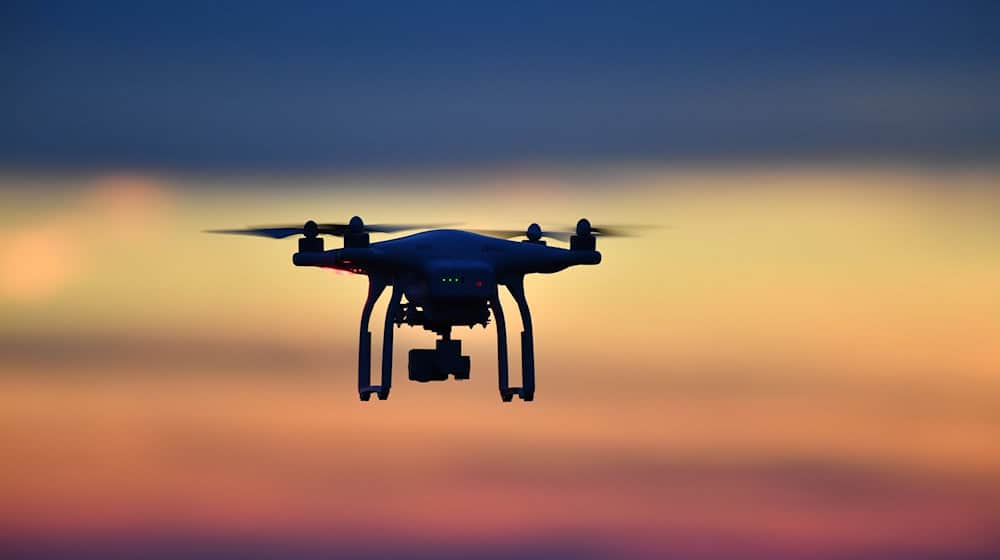 Eine Drohne  fliegt bei Sonnenuntergang über eine Wiese. / Foto: Felix Kästle/dpa