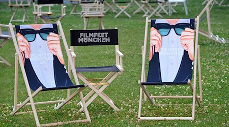 Liegestühle bedruckt mit dem Schriftzug "Filmfest München" stehen im Hof der Filmhochschule auf einer Wiese. / Foto: Ursula Düren/dpa