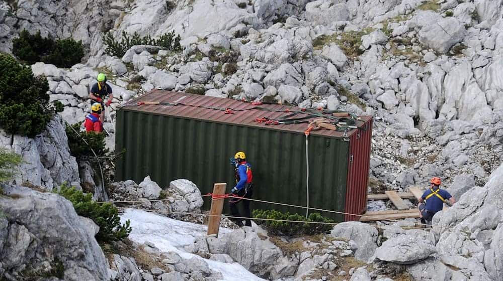 Einsatzkräfte stehen am Untersberg am Einstieg der Riesending-Schachthöhle bei einem Container. / Foto: Tobias Hase/dpa/Archivbild