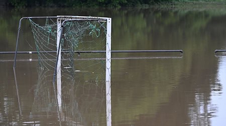 Ein Fußballtor spiegelt sich im Wasser auf einem überschwemmten Sportplatz. / Foto: Felix Kästle/dpa