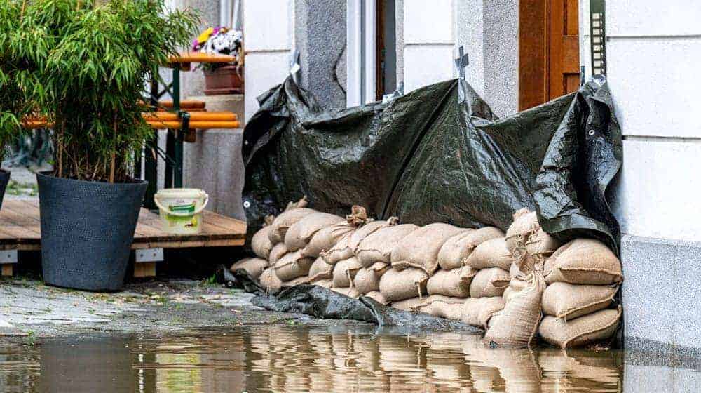 Sandsäcke liegen vor einem Haus in Passau. / Foto: Armin Weigel/dpa
