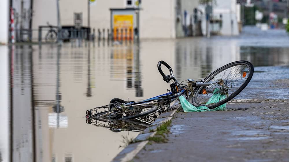 Ein Fahrrad liegt im Hochwasser der Donau. / Foto: Armin Weigel/dpa