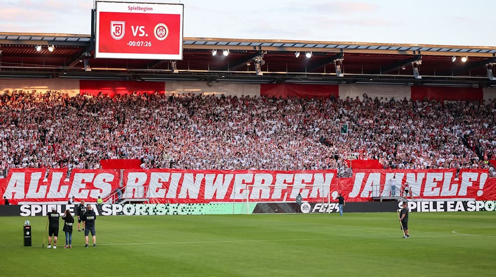 Die Regensburger Fans haben eine Choreo mit dem Spruch «Alles reinwerfen, Jahnelf!» aufgehangen. / Foto: Daniel Löb/dpa