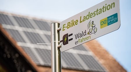 Vor dem Rathaus ist ein Schild mit dem Hinweis auf eine "E-Bike Ladestation" zu sehen. / Foto: Nicolas Armer/dpa