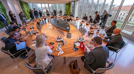 Die Minister und der Ministerpräsident sitzen zu Beginn der Sitzung des bayerischen Kabinetts gemeinsam am Tisch. / Foto: Peter Kneffel/dpa