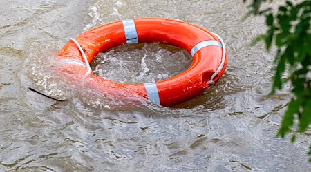 Ein Rettungsring schwimmt im Hochwasser. / Foto: Armin Weigel/dpa