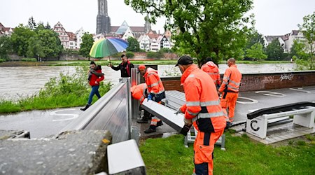 Mitarbeiter des Neu-Ulmer Baubetriebshofes bereiten sich auf das Hochwasser an der Donau vor und bringen Schutzwände an. / Foto: Marius Bulling/dpa