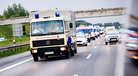 Ein Fahrzeugkonvoi aus Betreuungs- und Transporteinheiten vom Bayerischen Roten Kreuz, den Maltesern, der Johanniter-Unfallhilfe und dem Arbeitersamariterbund fährt über die Autobahn 8. / Foto: Matthias Balk/dpa