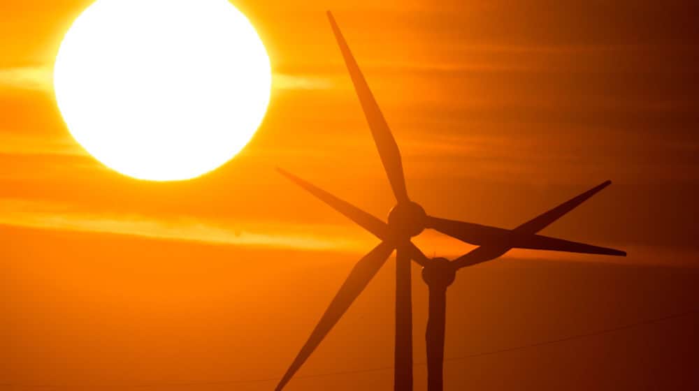 Die Sonne geht hinter Windrädern auf. / Foto: Julian Stratenschulte/dpa/Symbolbild