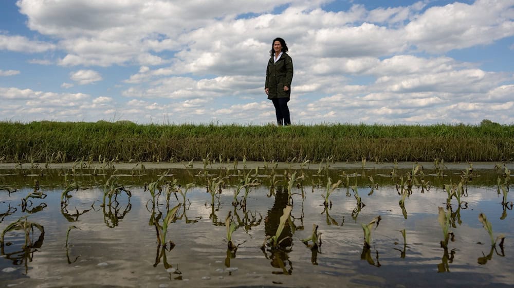 Michaela Kaniber, Landwirtschaftsministerin von Bayern, steht neben einem überfluteten Acker. / Foto: Stefan Puchner/dpa