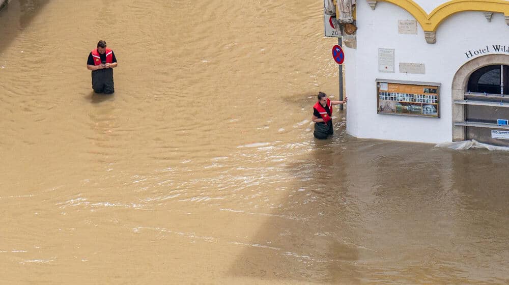 Rettungskräfte stehen im Hochwasser der Donau. / Foto: Armin Weigel/dpa