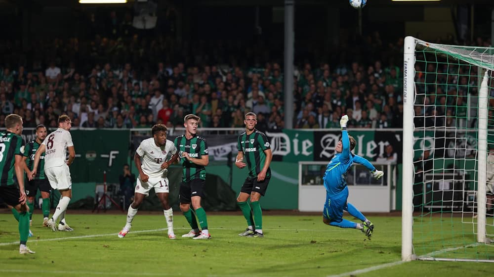 Münsters Torwart Johannes Schenk (r) pariert einen Ball vor Münchens Leon Goretzka (3.v.l) und Kingsley Coman (4.v.l). Bayern-Leihgabe Schenk bleibt in Münster. / Foto: Friso Gentsch/dpa