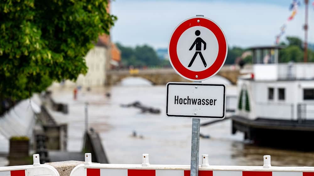 Ein Hochwasser Warnschild steht am Ufer der Donau. / Foto: Armin Weigel/dpa