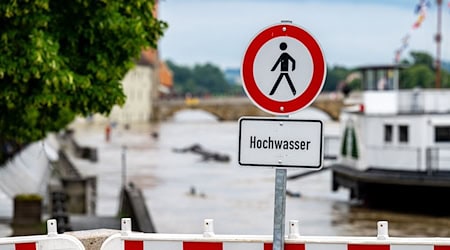 Ein Hochwasser Warnschild steht am Ufer der Donau. / Foto: Armin Weigel/dpa