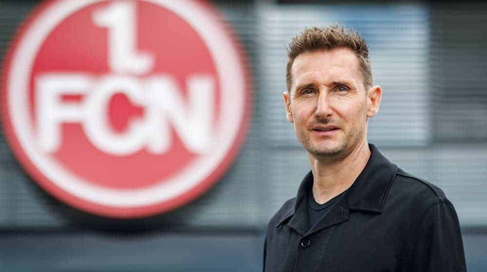 Der neue FCN-Trainer Miroslav Klose steht vor dem Vereins-Logo. / Foto: Daniel Karmann/dpa