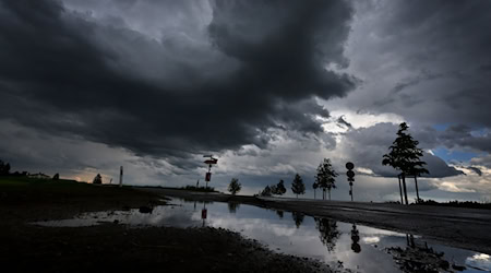 Dichte Regenwolken spiegeln sich in einer Pfütze. / Foto: Karl-Josef Hildenbrand/dpa/Symbolbild