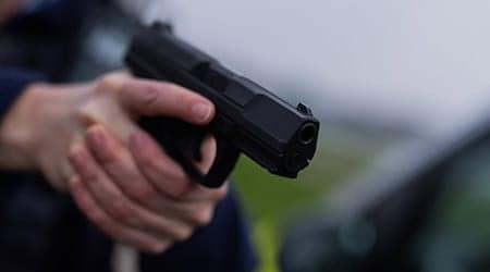Ein Polizist hält eine Pistole vom Typ Walther P99 in den Händen. / Foto: Rolf Vennenbernd/dpa