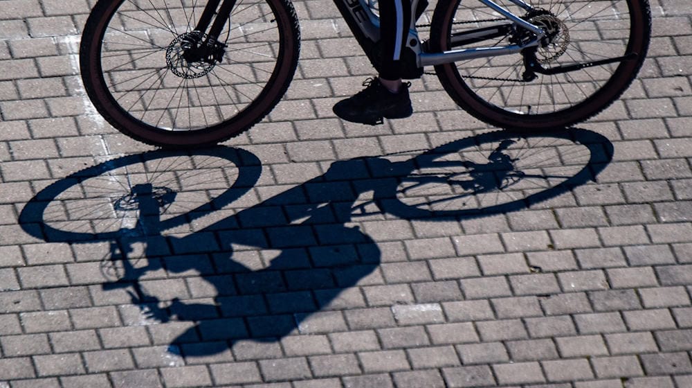 Eine Radfahrerin wirft einen Schatten. / Foto: Stefan Sauer/dpa/Symbolbild