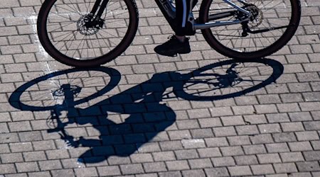 Eine Radfahrerin wirft einen Schatten. / Foto: Stefan Sauer/dpa/Symbolbild