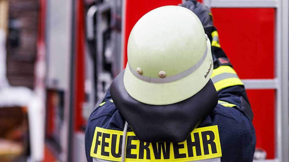 Ein Feuerwehrmann holt während einer Einsatzübung einer Freiwilligen Feuerwehr eine Leiter vom Dach eines Einsatzfahrzeugs. / Foto: Philipp von Ditfurth/dpa