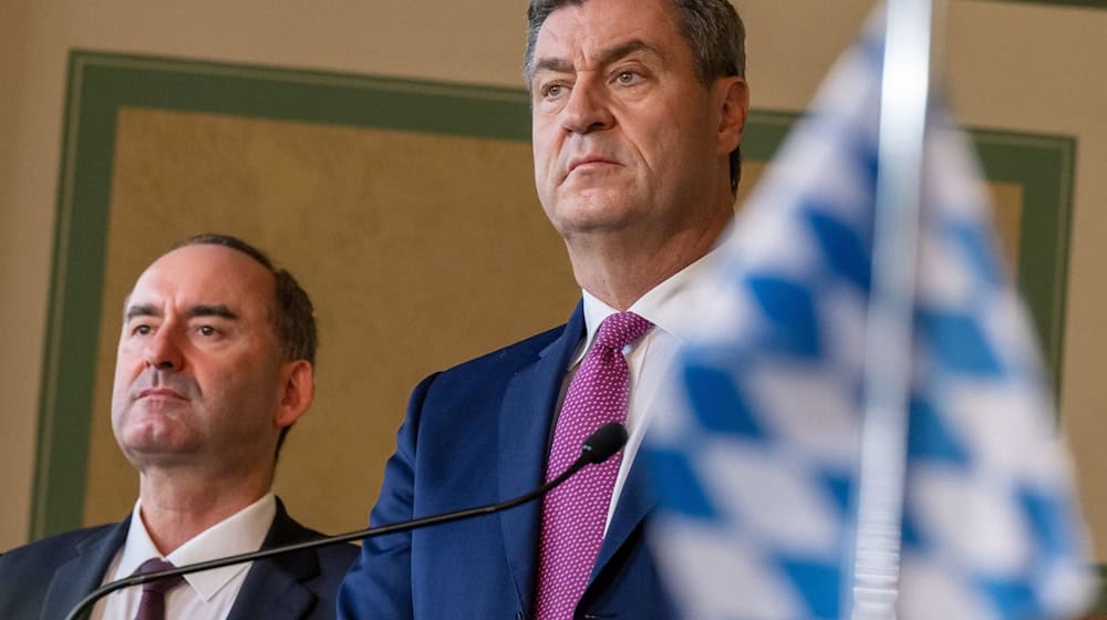 Hubert Aiwanger (l) und Markus Söder (CSU) nehmen im bayerischen Landtag an der Unterzeichnung teil. / Foto: Peter Kneffel/dpa