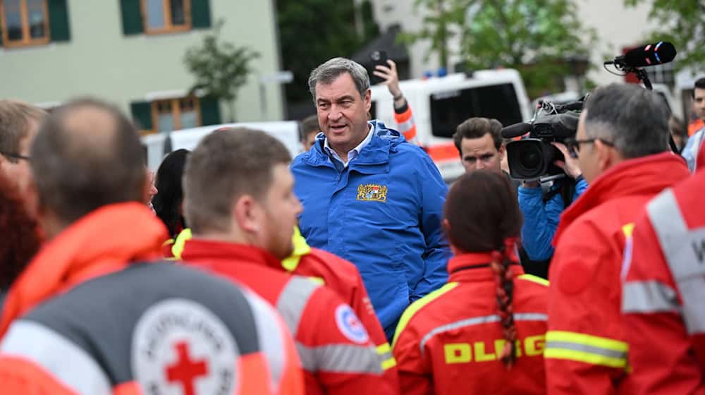 Bayerns Ministerpräsident Markus Söder (M, CSU) spricht zu Einsatzkräften verschiedener Rettungsdienste. / Foto: Sven Hoppe/dpa/Archivbild