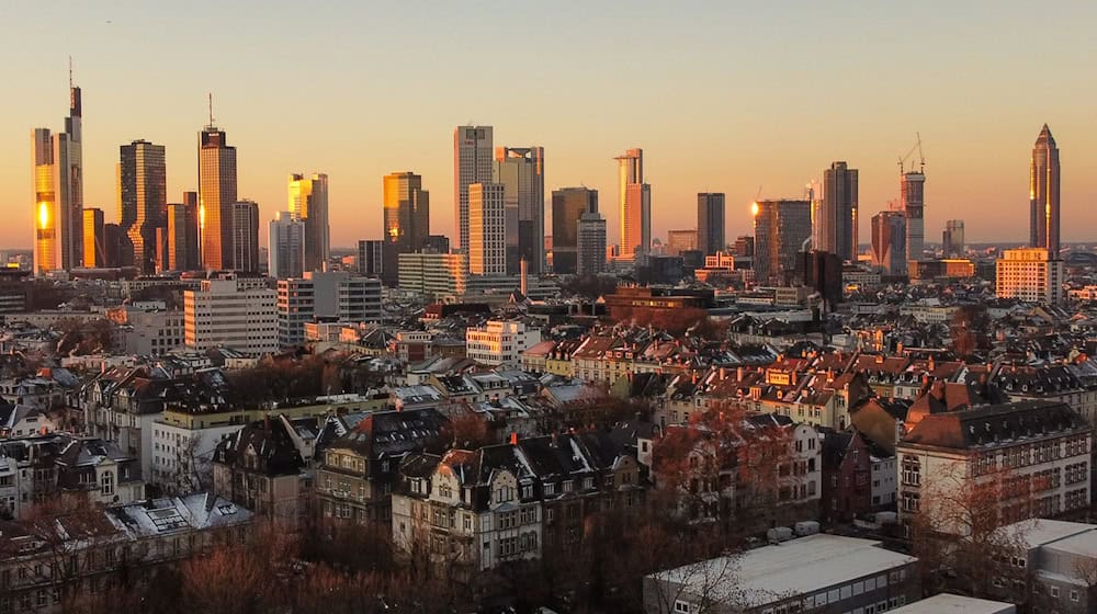 Das Licht der aufgehenden Sonne streift die Hochhäuser der Skyline von Frankfurt. / Foto: Boris Roessler/dpa