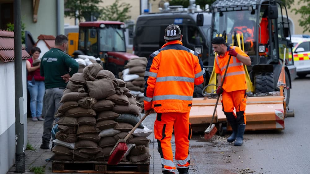 Helfer reinigen im Ortskern eine Straße. / Foto: Sven Hoppe/dpa