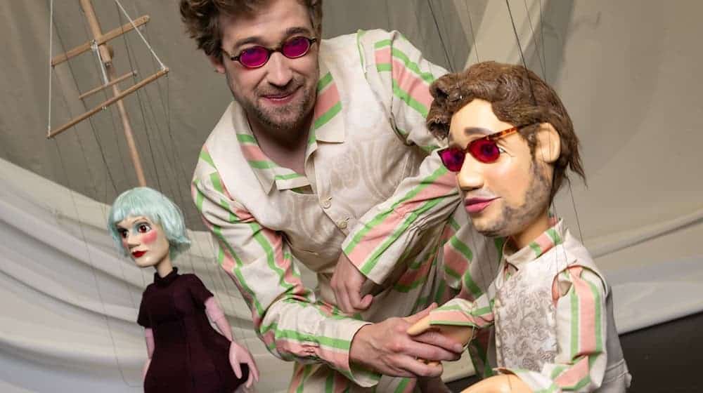 Der Schauspieler Julius Kuhn gibt im Probenraum des Staatstheaters der Marionette «Nathanael» die Hand. / Foto: Stefan Puchner/dpa