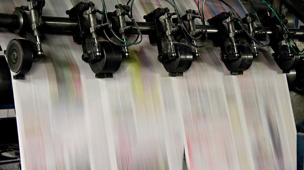 Bedrucktes Zeitungspapier läuft durch eine Druckmaschine. / Foto: Rene Ruprecht/dpa
