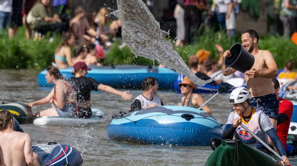 Das Wetter spielt mit: Junge Leute liefern sich auf der Donau beim Nabada eine Wasserschlacht. / Foto: Stefan Puchner/dpa